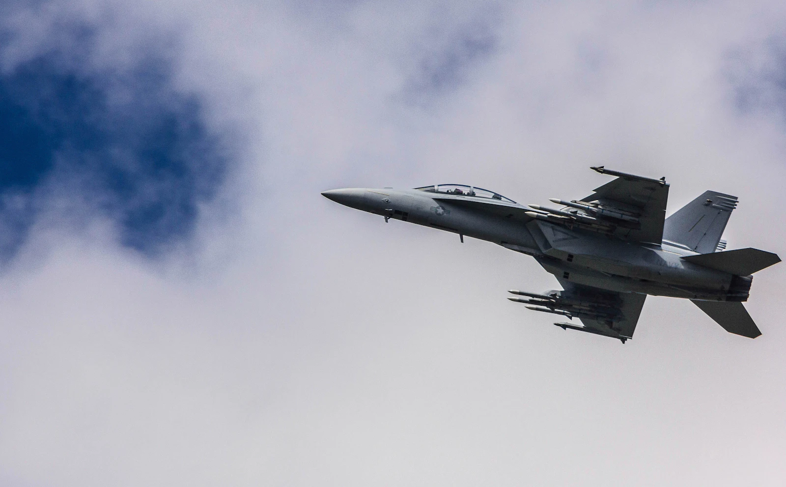 Military jet flying through clouds